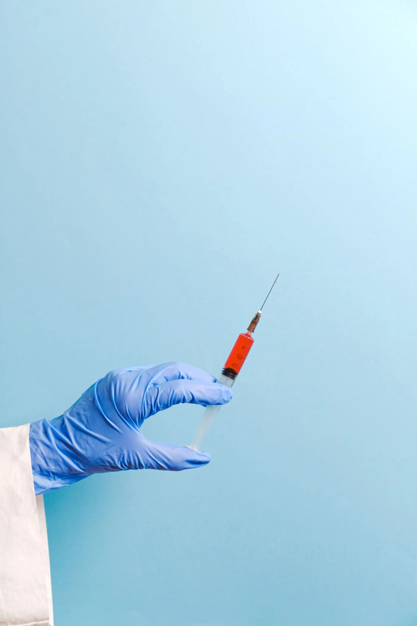 Doctor holding a syringe, preparing to administer a vaccine