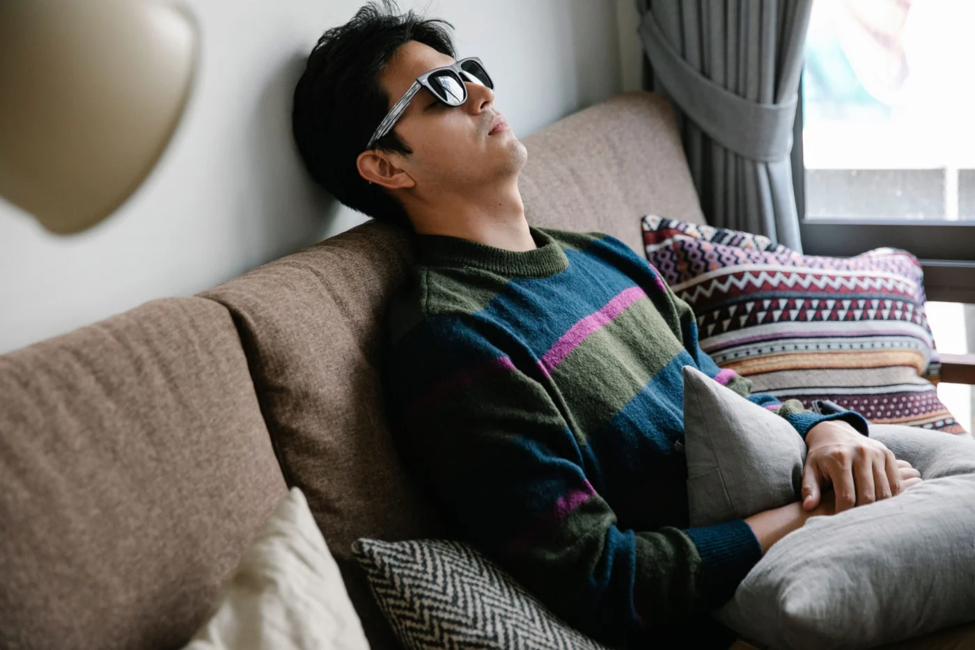 Man resting comfortably on a couch at home after a vaccination