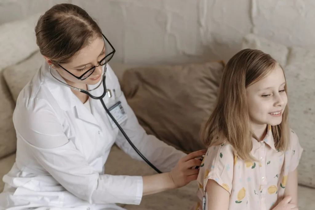 GP listening to a child's chest with a stethoscope during an appointment