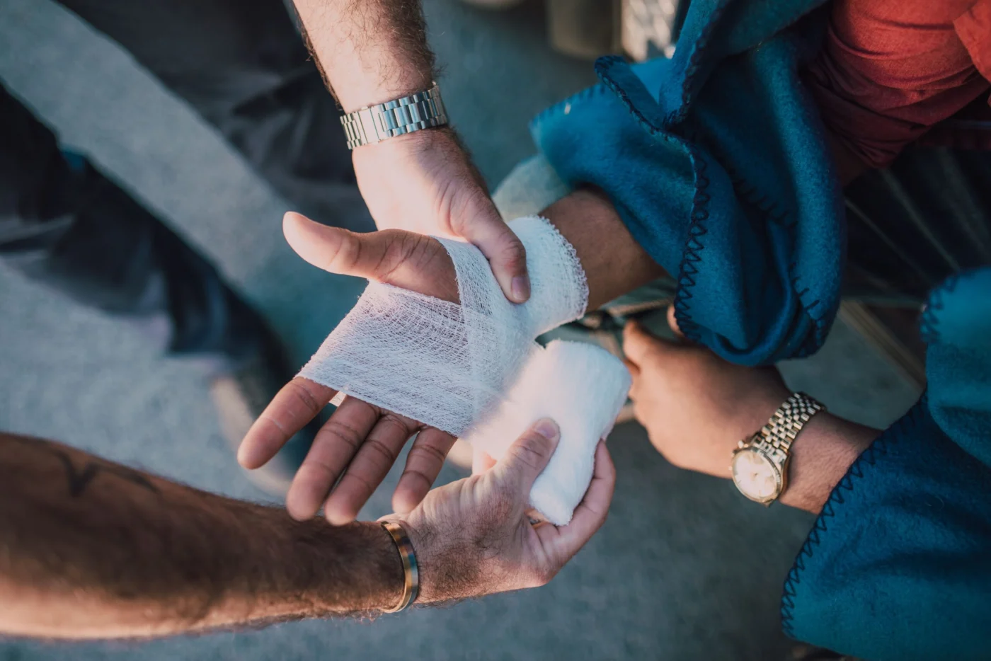 Caregiver gently applying a bandage to another person's injured hand