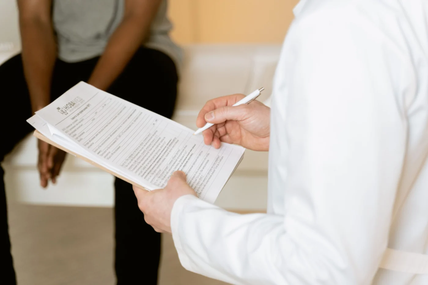 Doctor reviewing a medical form with a patient during a clinic consultation